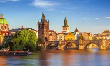 Charles Bridge is a medieval stone arch bridge that crosses the Vltava river in Prague